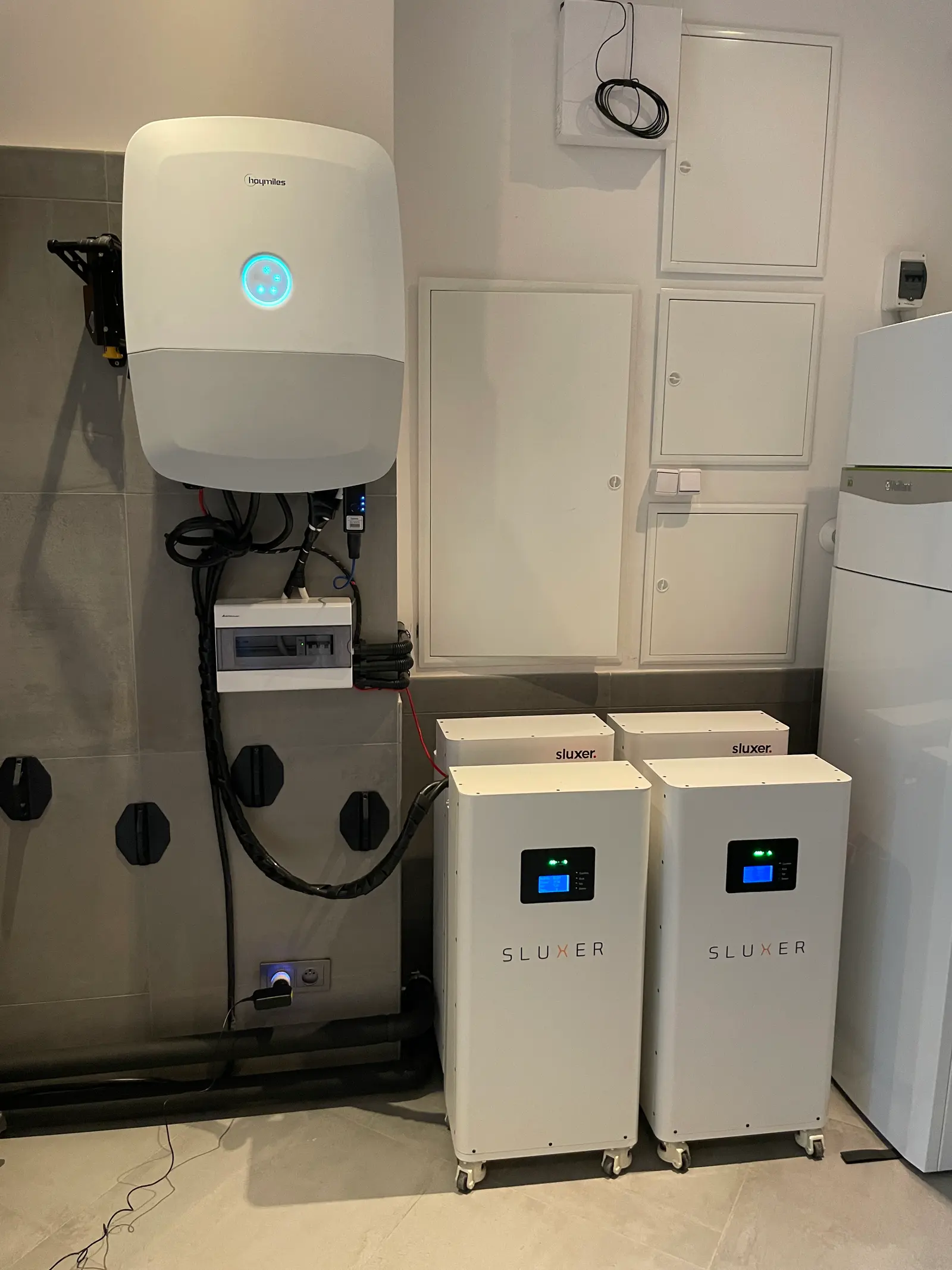 Falownik na ścianie i dwa magazyny energii SLUXER w pomieszczeniu technicznym