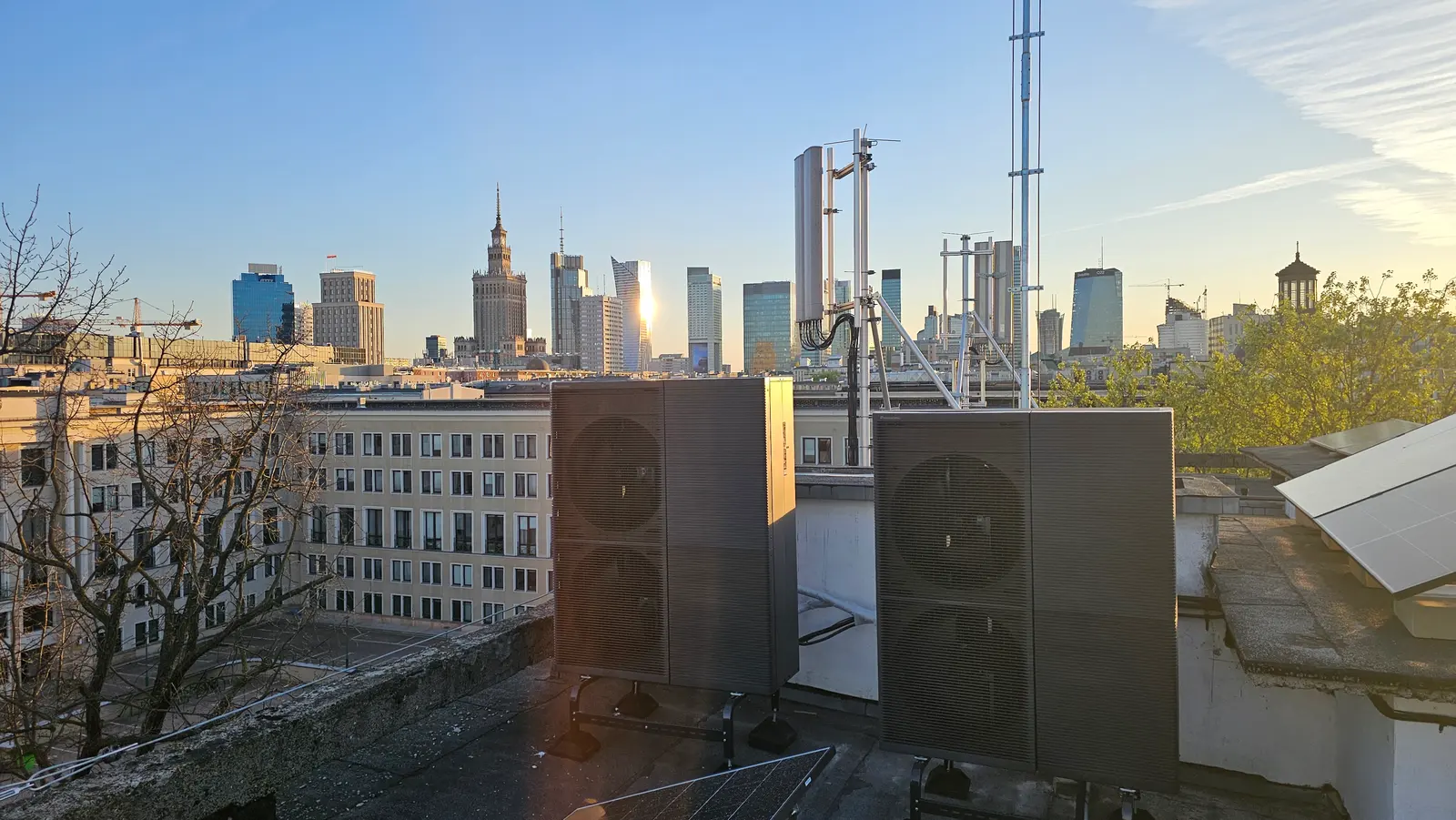 Dwie duże jednostki zewnętrzne na dachu budynku, w tle panorama z wieżowcami